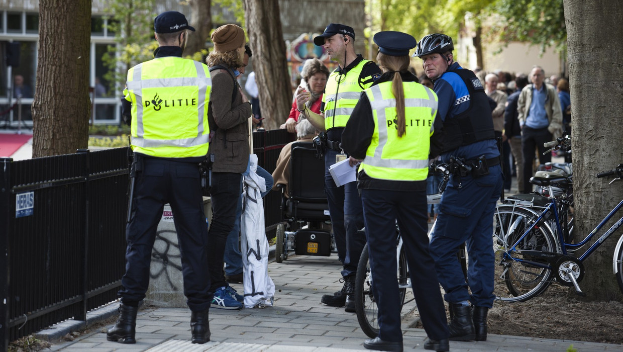 De verslaggever trok met twee spandoeken met teksten tegen het koningshuis naar een bezoek van koning Willem-Alexander in Baarn. Binnen tien minuten was hij aangehouden. Beeld Olaf Robberse   