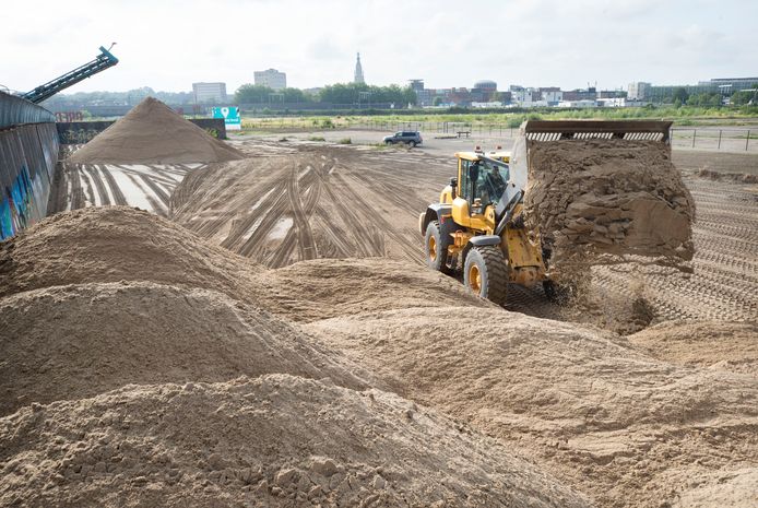 Zand word gestort voor de aanleg van een tijdelijk stadspark op het voormalige CSM-terrein.