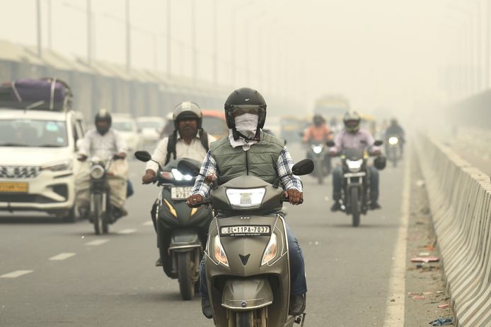 Verkeer rijdt over een door mist en smog omgeven weg in New Delhi.