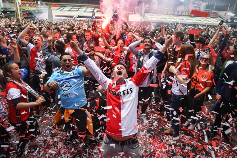 Feyenoordfans in het centrum van Rotterdam vieren een doelpunt in de beslissende wedstrijd tegen Heracles Almelo. Beeld EPA