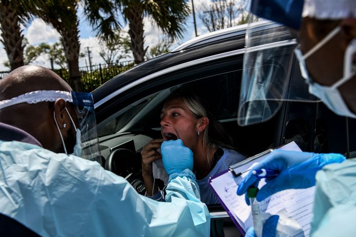 In Miami wordt een vrouw getest door medisch personeel in een drive-through.