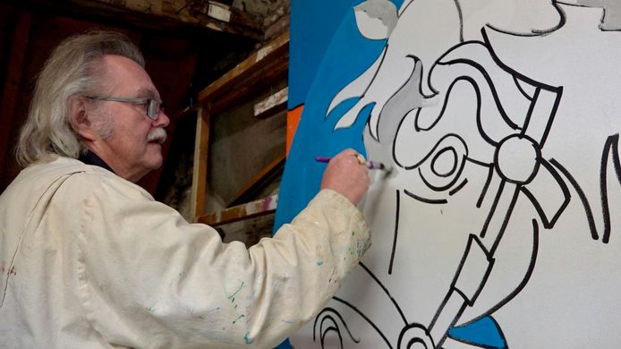 Gert Baaten schildert op zolder van café De Bommel één van de panelen voor de carnavalsversiering