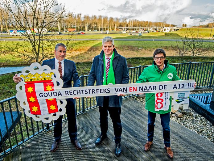 Nico Voogt overhandigt samen met Gouds CDA-raadslid Martijn van der Wind een uit de kluiten gewassen sleutel aan CDA-Kamerlid Chris van Dam om angst voor op slot gaan van Goudse Poort de op en afrit van de A12 onder de aandacht te brengen.