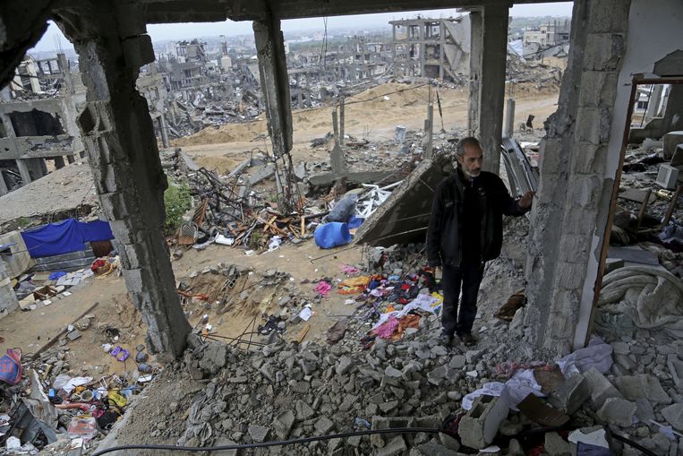 De Palestijn Ahmad Atawneh staat tussen de puinhopen van zijn woning in de Gazastrook. Beeld Adel Hana / AP