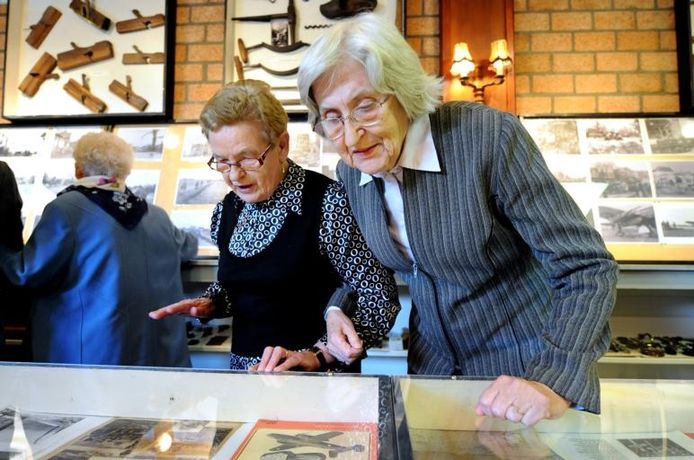 De dames Mol (links) en Van de Merbel buigen zich over de vitrines vol herinneringen aan de bevrijding. foto Edmund Messerschmidt/het fotoburo