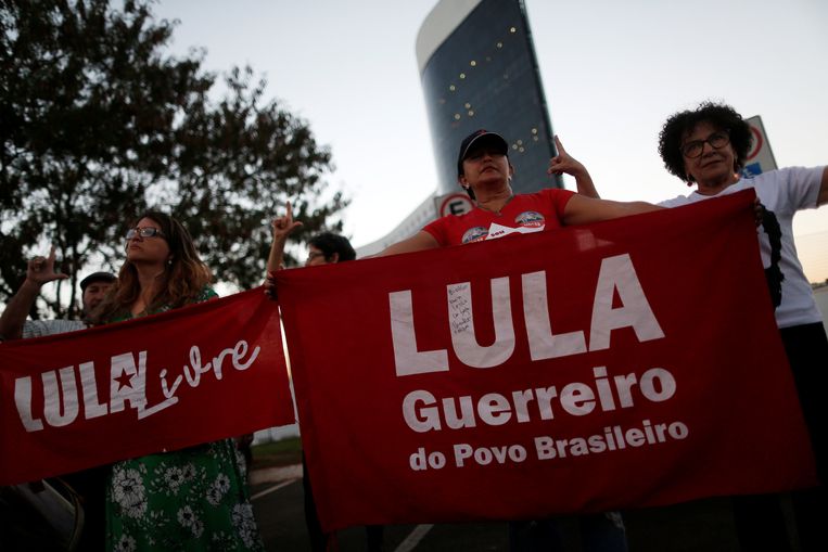 Voor het gebouw van het electoraal hof in de Braziliaanse hoofdstad Brasília demonstreren aanhangers van oud-president Lula met spandoeken waarop onder meer de tekst 'Lula, strijder van het Braziliaanse volk' is geschreven. Beeld REUTERS