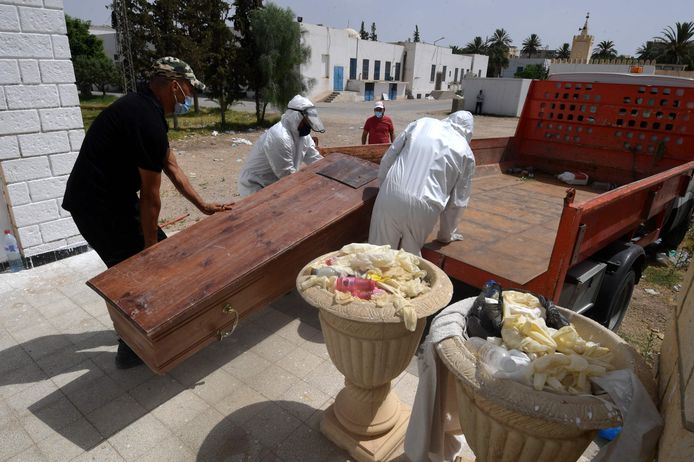 Het lichaam van een overleden Tunesische coronapatiënt wordt op een truck geladen.