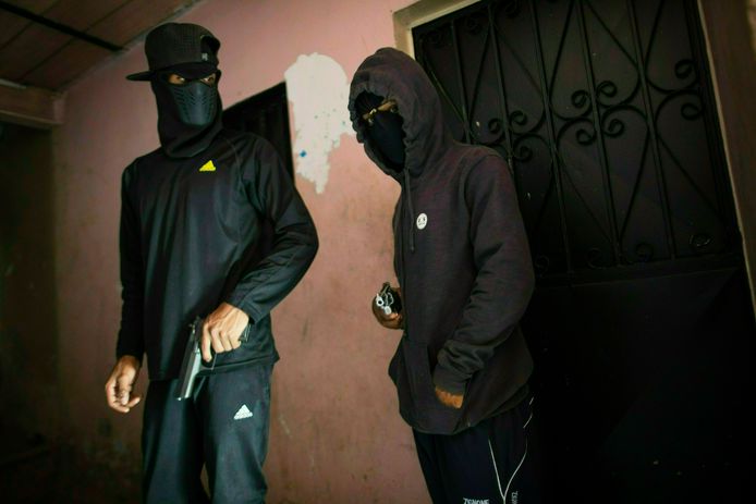 Twee gemaskerde criminelen uit Caracas, die deze week poseerden voor een fotograaf van Associated Press. “Als je je magazijn leegschiet ben je zo vijftien dollar kwijt.”