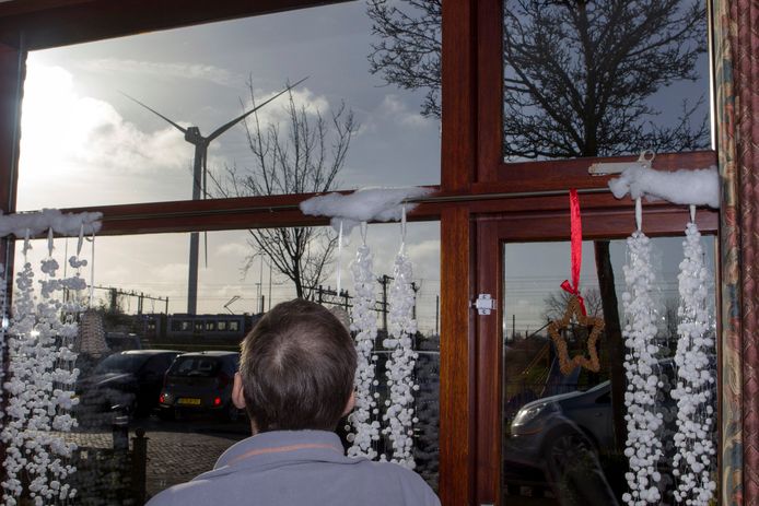 De windmolen in Leidschendam-Voorburg vanuit het raam van omwonenden met de RandstadRail die voorbij rijdt.