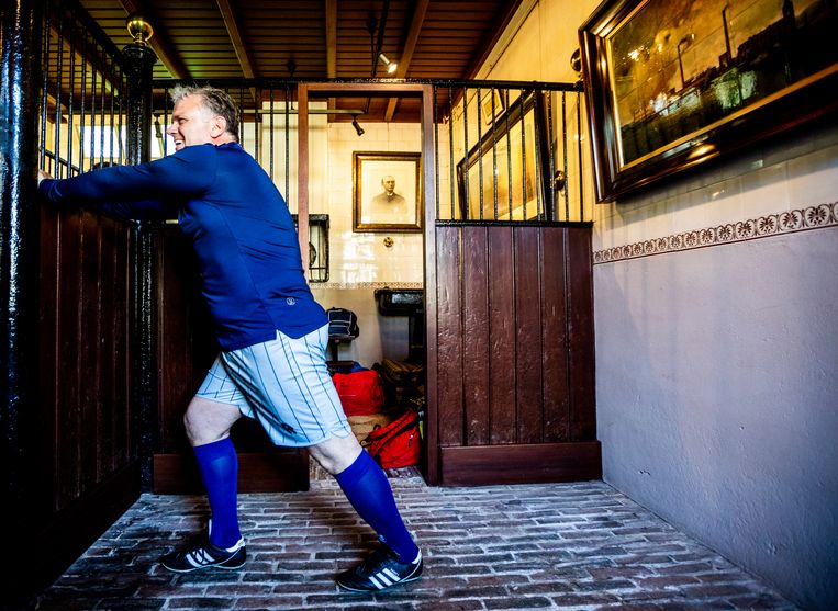 Een speler rekt zijn spieren in het oude koetshuis. Beeld 