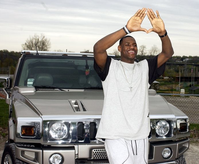 De Amerikaanse basketter LeBron James poseert bij een van zijn Hummers.