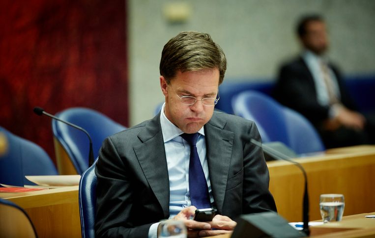 Premier Rutte gebruikt zijn telefoon in de Tweede Kamer.  Beeld ANP