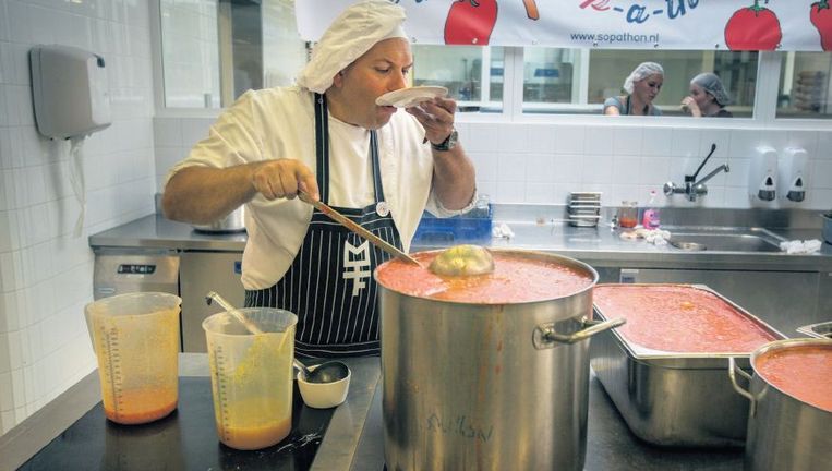 Een van de koks van de soepmarathon in Leeuwarden keurt zijn werk alvorens er zijn zegen aan te geven. Beeld Herman Engbers