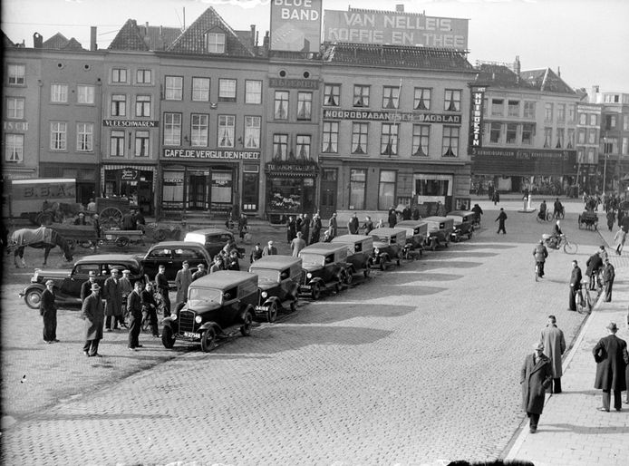 De bestelwagens van Het Huisgezin staan opgesteld voor het kantoor aan de Markt in Den Bosch. De foto is uit 1937.