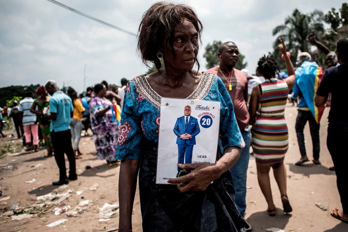 Een aanhanger van Tshisekedi poseert met een foto van hem.