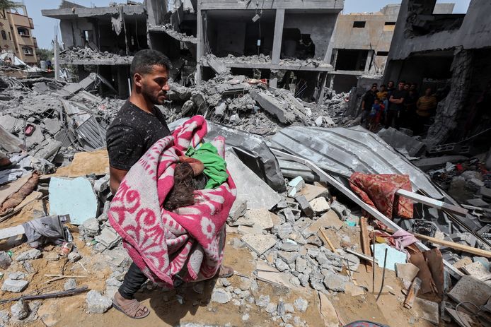 Een man met het lichaam van een omgekomen kind na een bombardement in Nuseirat, , centraal gelegen in de Gazastrook.