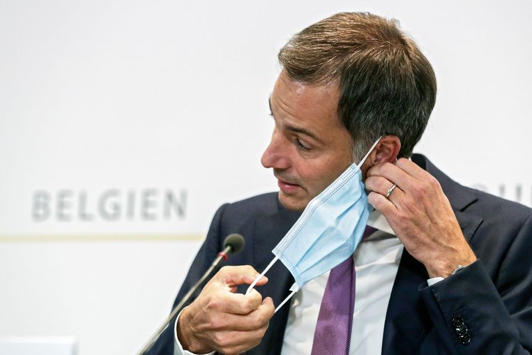 Premier Alexander De Croo (Open Vld) neemt zijn mondmasker af tijdens de persconferentie na het Overlegcomité.  Beeld Photo News