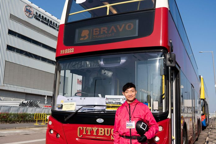 Frankie Chow d'Ulu Travel devant l'un de ses bus "silencieux". Il porte également un costume de la série Squid Game.