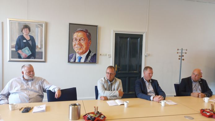 Vlnr: Frans Stravers, Jan Peters Rit, Mark van Schaijk en formateur Godfried van Gestel. Op de achtergrond portretten van oud-burgemeesters Rianne Donders en Berry Link.
