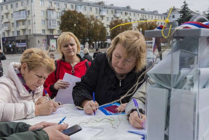 Mensen brengen hun stem uit aan een stembureau buiten in Loehansk.