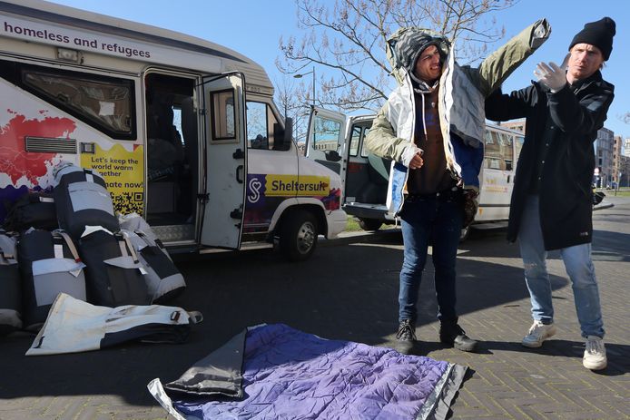 De dakloze Fazlullah (35) krijgt uitleg over een sheltersuit door Bas Timmer (r), oprichter van Sheltersuit Foundation. Twintig van deze pakken die extra bescherming bieden tegen kou en regen zijn uitgedeeld in Breda. Het straatteam van de SMO zorgt voor de verdeling.