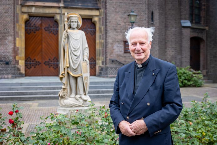 Vicaris Alphons Woolderink voor het beeld van Sint Joris. Het is zijn geschenk aan de parochie ter ere van zijn 70ste verjaardag.