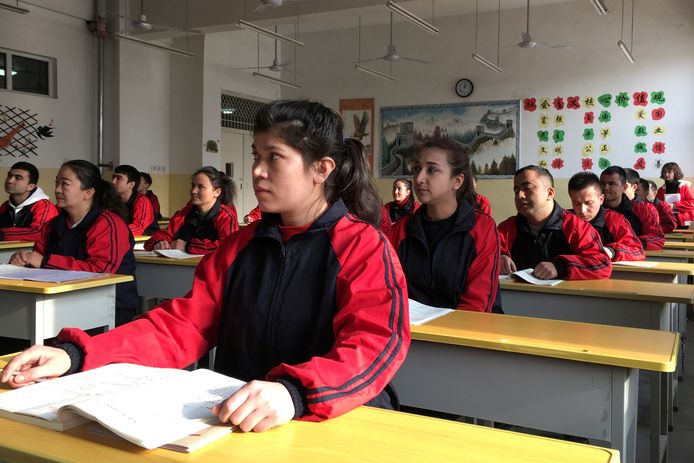 Bewoners in het 'heropvoedingscentrum' in de stad Kashgar wonen een les Chinees bij tijdens een bezoek dat door de overheid georkestreerd was.