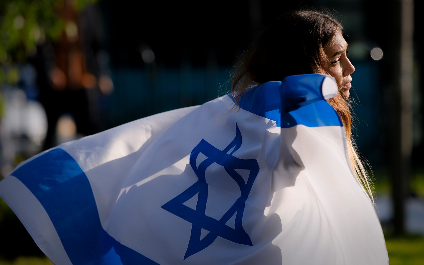 Een vrouw wandelt met een vlag van Israël bij een protest tegen het geweld in het land.