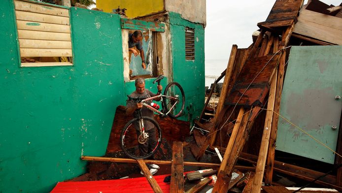 Een man helpt zijn buurman na orkaan Maria
