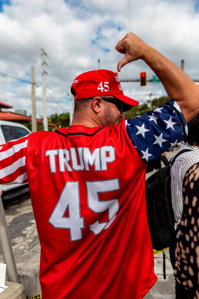 Een aanhanger van Donald Trump in West Palm Beach staat klaar om te zwaaien naar het autokonvooi.