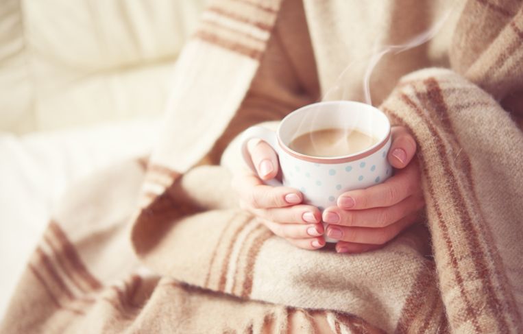 warm cup of hot coffee warming in the hands of a girl Beeld Thinkstock