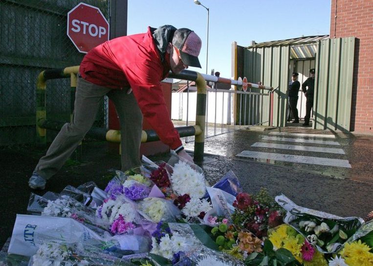Protestanten en katholieken betuigen trouw aan het vredesproces na moorden op soldaten en een politieman. Een vrouw legt bloemen. Foto EPA Beeld 