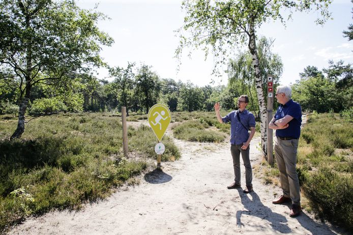 Gedeputeerden Jan De Haes en Rembrandt De Koninck lanceren de pins uit de GroenZoeker op de Kesselse Heide.