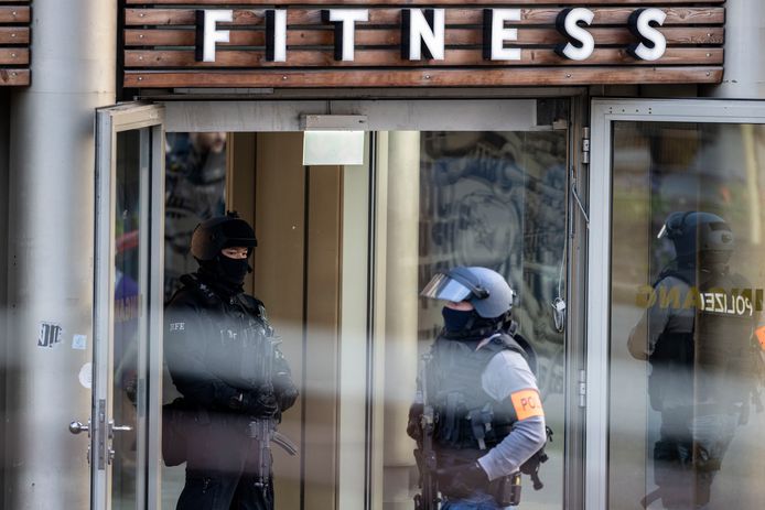 Zwaargewapende politieagenten aan de ingang van de fitnessclub, waar omstreeks 17.00 uur meerdere mensen zijn neergestoken.