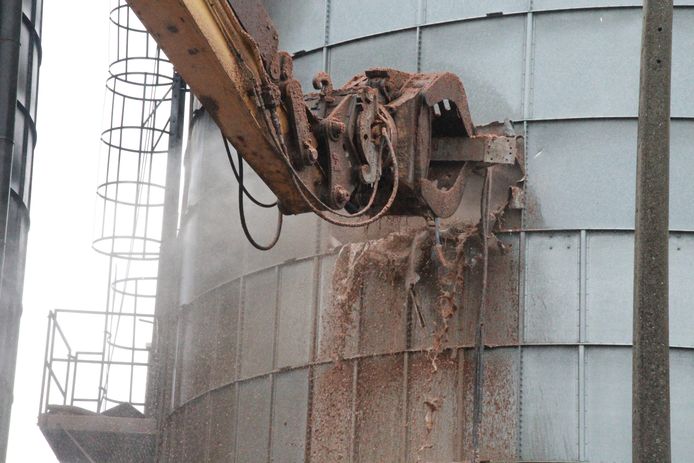 De ontplofte silo wordt leeggemaakt.