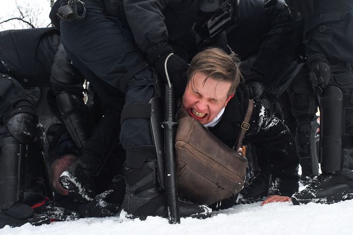 Een betoger wordt tegen de grond geduwd in het besneeuwde Sint-Petersburg.