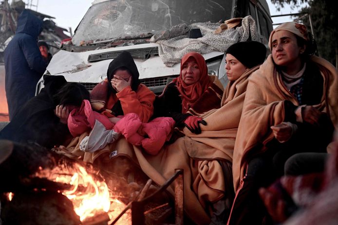 Mensen wachten op nieuws over hun vermiste familieleden tussen vernielde gebouwen in Kahramanmaras.
