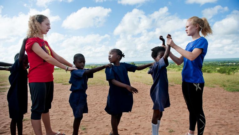Twee vrijwilligers geven sportlessen aan kinderen in een schooltje in Zambia, Afrika. Beeld An-Sofie Kesteleyn