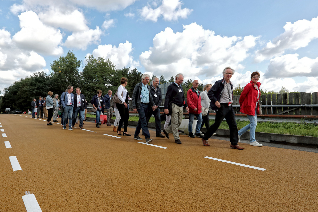 Route van de turf, de deelnemers laten hun fietsen achter en wandelen naar het treintje wat staat te wachten. Brug over de A58