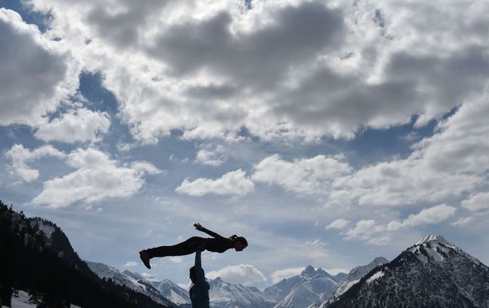 De Sloveense Ema Klinec doet met haar coach oefeningen, voorafgaand aan een schansspringwedstrijd in Oberstdorf in Duitsland. Foto Christof Stache