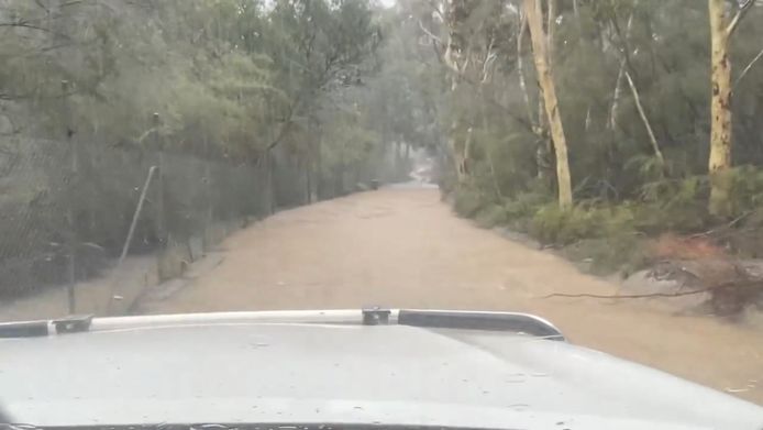 Een overstroomde weg in Somersby, New South Wales.