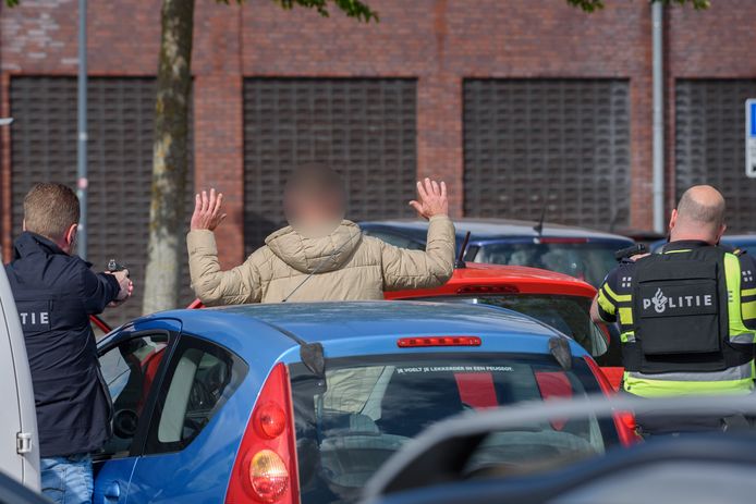 Agenten houden de eerste verdachte onder schot en maken zich gereed om hem te arresteren.