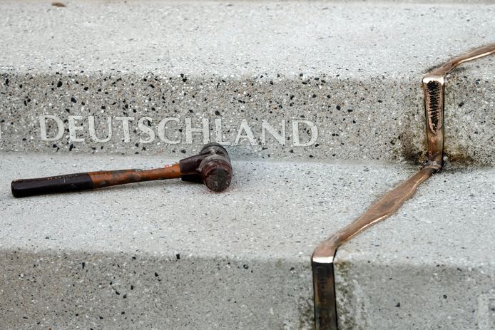 Een hamer ligt bij het gedenkteken van de aanslag: het woord Duitsland naast een gouden 'barst' in de grond, dat de diepe wonden die de aanslag naliet, syboliseert.