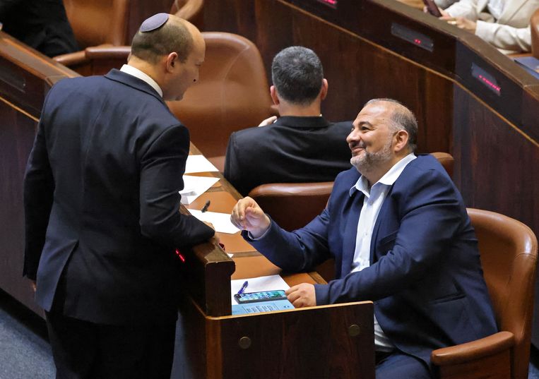 Ultranationalist Naftali Bennett (l), die een nieuwe regering zal aanvoeren, in gesprek met Mansour Abbas, voorman van de Ra’am-partij. Beeld AFP