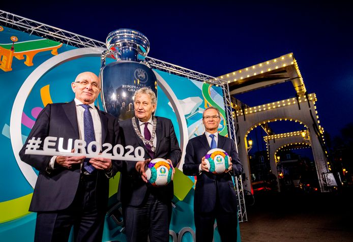 Amsterdam is gastheer van twee groepsduels op het EK 2020, dat in meerdere landen wordt afgewerkt. Op de foto poseert Michael van Praag op de Magere Brug met de in oktober overleden burgemeester Eberhard van der Laan en UEFA-gedelegeerde Giorgio Marchetti voor de onthulling van het Logo.