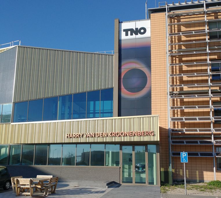 Het oude (rechts, met traditionele zonnepanelen voor de gevel) en het nieuwe lab van TNO in Petten. De naam TNO en het kunstwerk eronder kunnen met zonnepanelen gevormd worden. Beeld Vincent Dekker