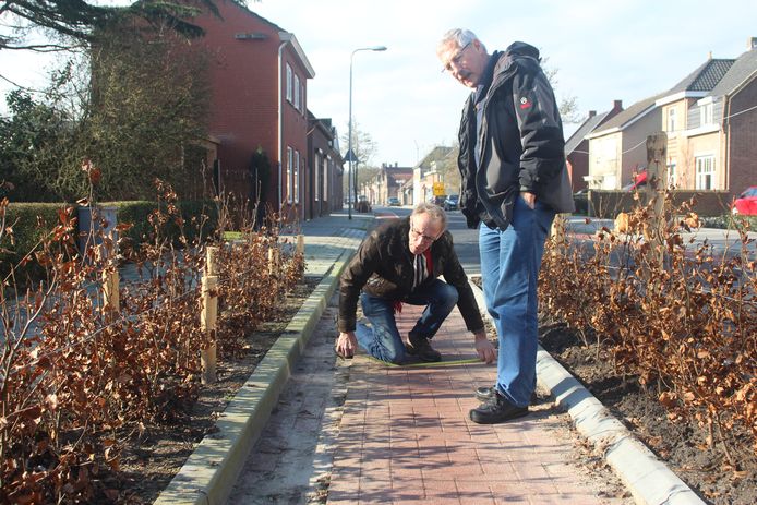 Piet Brosens en Nico Geers van de Fietsersbond meten de niveauverschillen in de Sint Janstraat. archieffoto BN DeStem