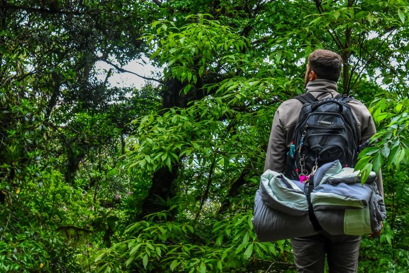 Man met backpack rugzak in een bos