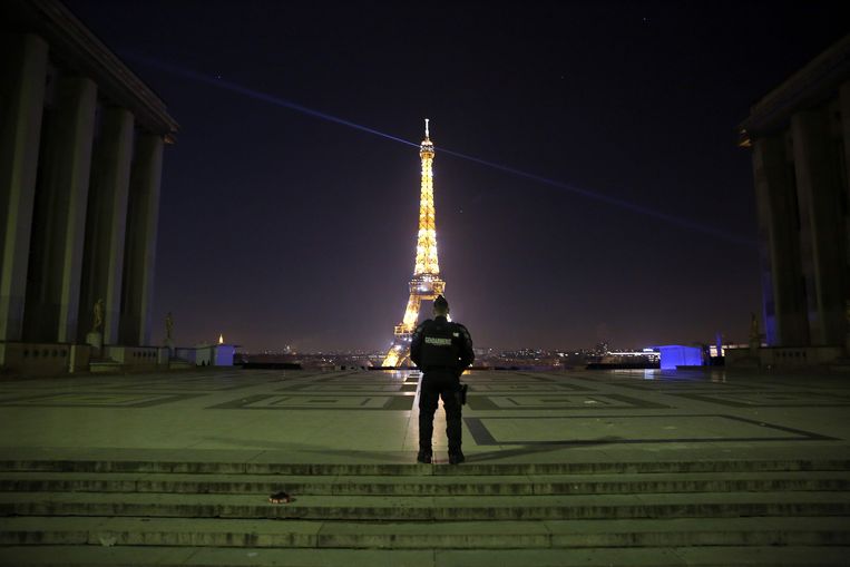 Een politieagent controleert op het naleven van de avondklok tijdens de jaarwisseling in Parijs.  Beeld AFP