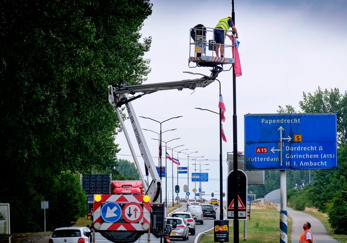 Een ZZP’er op een hoogwerker verwijdert vandaag omgekeerde vlaggen op de Edisonweg in Alblasserdam, wat hem naar eigen zeggen op tal van verwensingen is komen te staan.